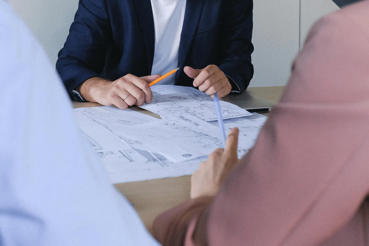 Professionals discussing blueprints and architectural designs at a table.
