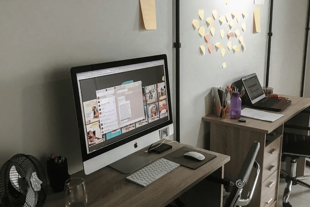 Modern home office with iMac and laptop workspace setup.
