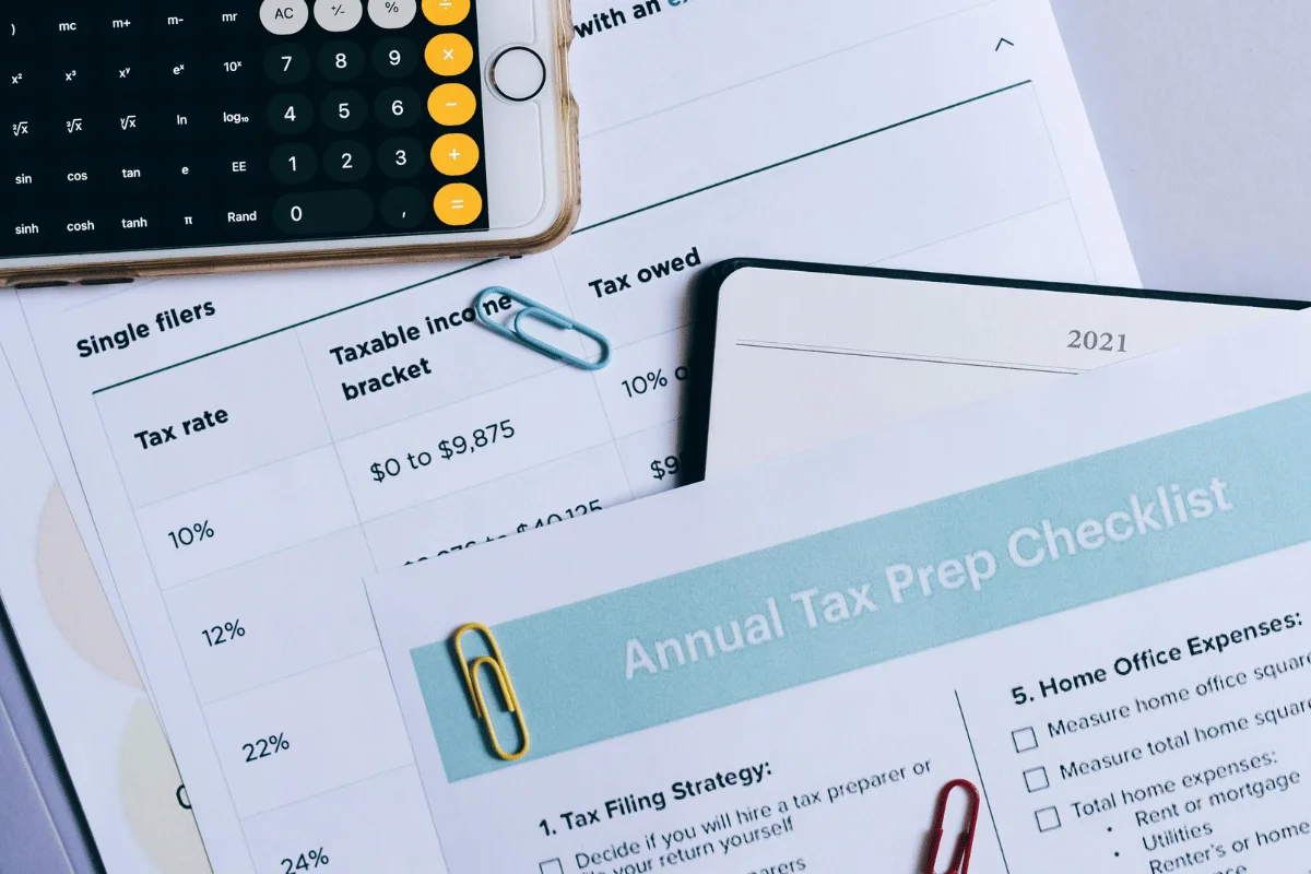 Tax preparation checklist with a smartphone calculator and tax rate chart.
