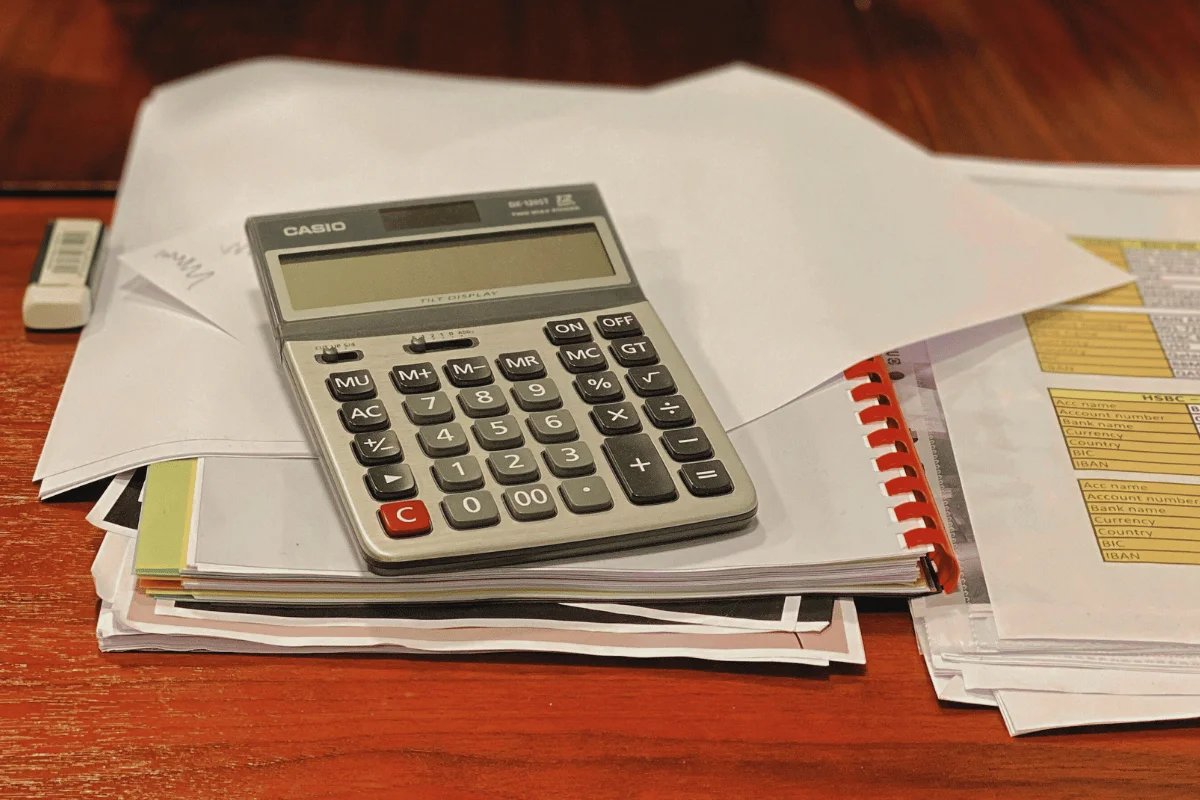 Desk with Casio calculator placed on top of financial paperwork.