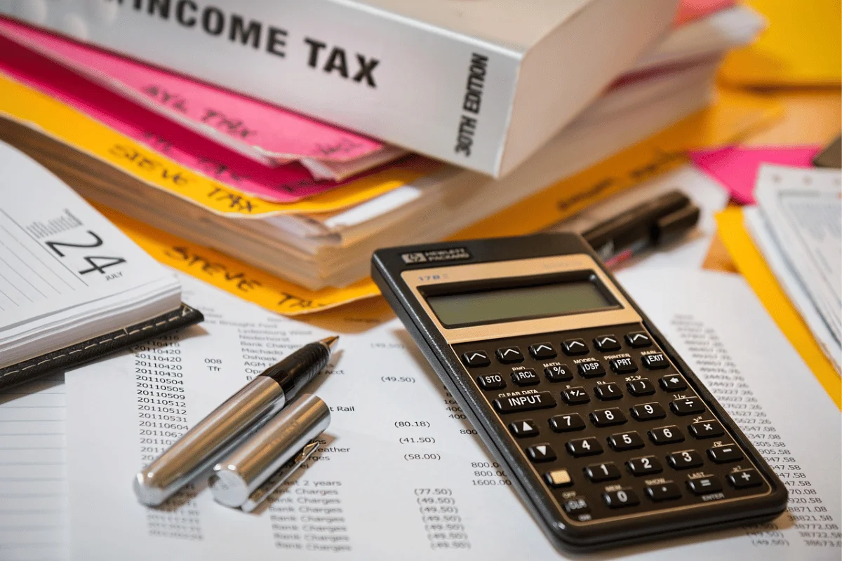 Calculator and financial documents on a desk for accounting work.