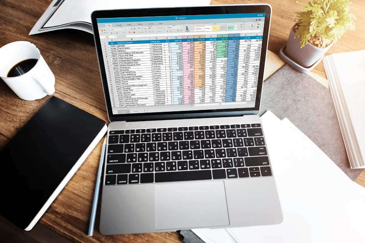 Bookkeeping template displayed on laptop in home office setting.