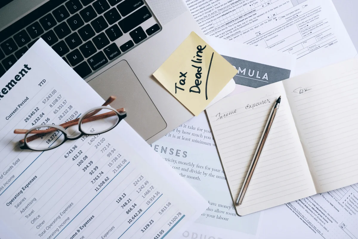 Business financial statement and tax documents with a reminder note for the tax deadline.