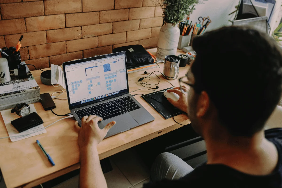 Man working on a business strategy diagram on a laptop at a desk.