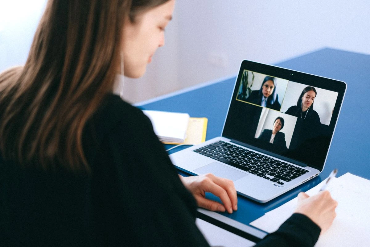 Person on a video call with three other people from her laptop.